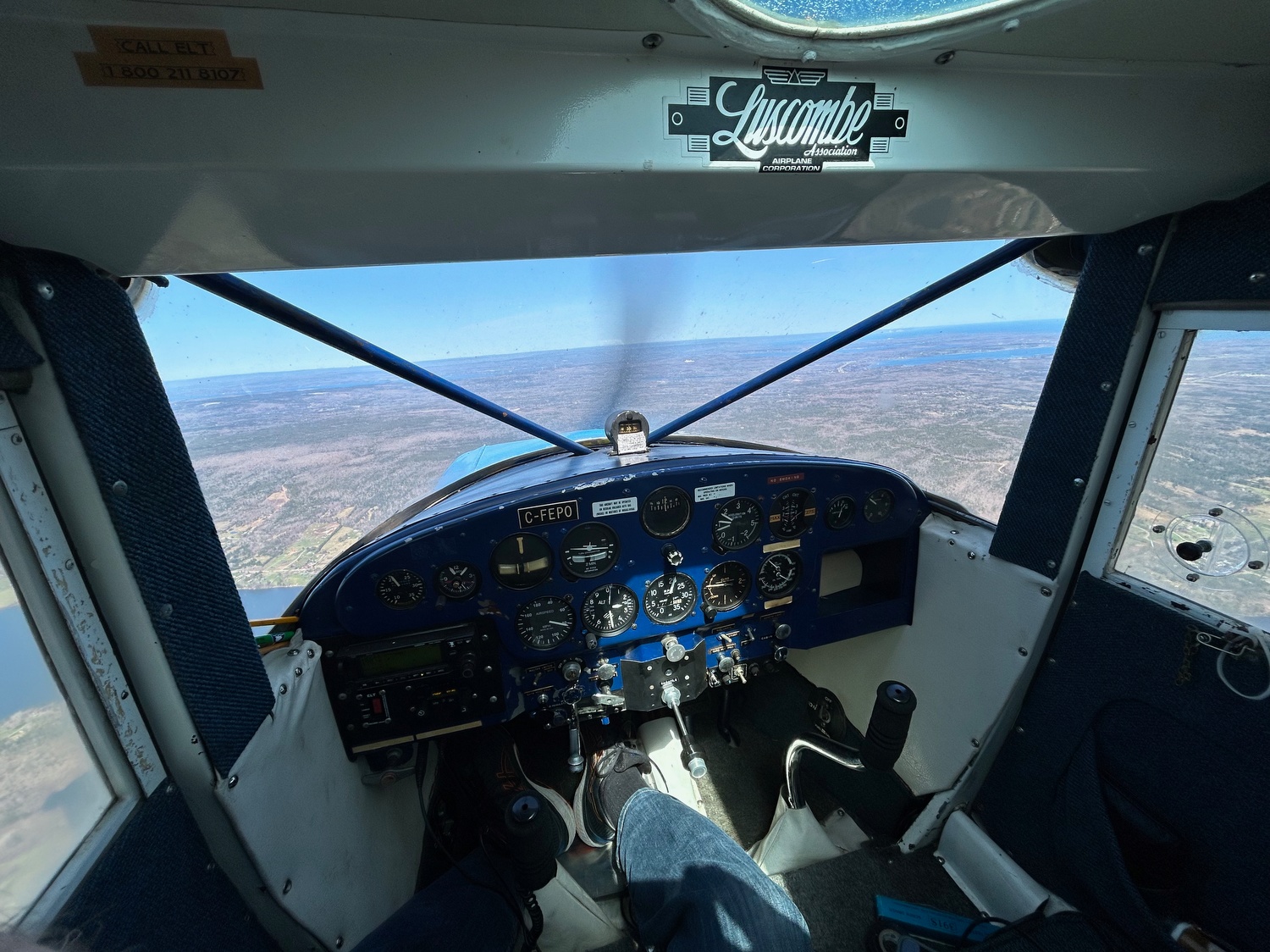 Wide angle photo of C-FEPO’s cockpit and panel over the Cape Breton Highlands, 2025 