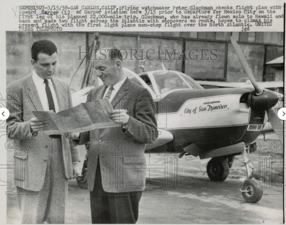 Photo caption reads: SXPO31507-3/15/58 SAN CARLOS, CALIF. Flying watchmaker Peter Gluckman checks flight plan with Howard Harper (L) of Harper Aviation here 3/15 prior to departure for Mexico City on the first leg of his planned 22,000-mile trip. Gluckman, who has already flown solo to Hawaii and back and made two flights across the Atlantic with stopovers en route, hopes to climax his present flight with the first light plane non-stop flight over the North Atlantic. UNITED PRESS TELEPHOTO photographer unknown 