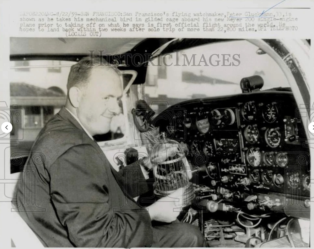 Photo Caption reads: SXPO 8/22/1959: San Francisco: San Francisco's flying watchmaker, Peter Gluckmann, 33, is shown as he takes his mechanical bird in gilded cage aboard his new Meyer 200 single-engine plane prior to taking off on what he says is first official flight around the world. He hopes to land back within two weeks after solo trip of more than 22,800 miles. UPI TELEPHOTO. Photographer unknown. 